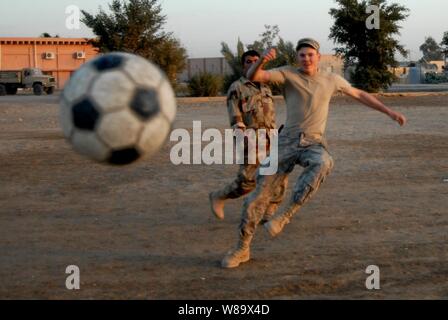 Circuit de l'armée américaine. Casey de la Wailes 1er Escadron, 10e Régiment de cavalerie, 2e Brigade Combat Team, 4e Division d'infanterie, efface la balle pendant un match de football avec des soldats iraquiens à Mahawil, l'Iraq, le 14 décembre 2008.