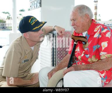 La Marine américaine a pris sa retraite le Lieutenant John W. Finn parle avec le Capitaine Richard cuisines, commandant de la base navale de Pearl Harbor, au cours du voyage de Finn voir le USS Arizona Memorial à bord du bateau blanc qui porte son nom le 6 décembre 2009. Finn, le plus vieux, récipiendaire de la médaille d'honneur a reçu la médaille d'Honneur pour l'héroïsme au cours de l'attaque japonaise sur Pearl Harbor le 7 décembre 1941. Banque D'Images