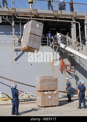 Des secours sont chargés dans le landing ship dock amphibie USS Carter Hall (LSD 50) à la station navale des États-Unis à Guantanamo Bay, Cuba, pour appuyer l'opération réponse unifiée sur le 24 janvier 2010. La station navale est de fournir un soutien logistique à l'Carter Hall pendant que le navire se prépare à sa mission d'aide humanitaire. Le Carter Hall sera le transport des marchandises et les Marines du bataillon logistique de combat 22 à Haïti. Banque D'Images