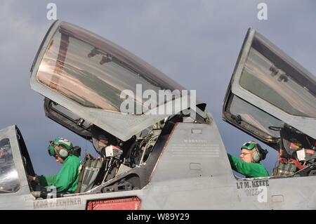 L'aviateur de la Marine américaine Cory Torres et maître de 1re classe Charles Berlemann, tous deux affectés à l'escadron tactique d'attaque électronique 135, réaliser des contrôles sur un EA-6B Prowler de systèmes avioniques de l'avion à bord du porte-avions USS Nimitz (CVN 68) en cours dans le Nord de la mer d'Oman, le 18 décembre 2009. Le groupe aéronaval du Nimitz est en déploiement dans le 5e flotte américaine zone d'exploitation. Banque D'Images