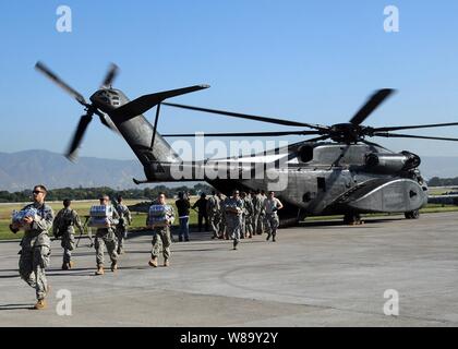 Les soldats de l'armée américaine décharger de la nourriture et des fournitures d'une marine MH-53E Sea Dragon hélicoptère du porte-avions USS Carl Vinson (CVN 70) à l'aéroport de Port-au-Prince, Haïti, le 15 janvier 2010. L'armée américaine mène des opérations d'aide humanitaire et de secours après un séisme de magnitude 7,0 a causé de graves dommages dans et autour de Port-au-Prince le 12 janvier 2010. Banque D'Images