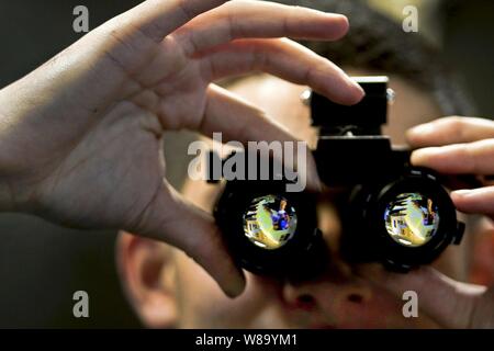 Matelot de la Marine américaine Garrick Haye ajuste une série de lunettes de vision de nuit à l'intérieur d'un atelier d'entretien intermédiaire à bord du porte-avions USS Carl Vinson dans l'océan Pacifique sur le 6 janvier 2011. Le Carl Vinson et Carrier Air Wing 17 sont déployés aux États-Unis 7e flotte zone de responsabilité. Haye est un electricianís aviation mate affecté à la maintenance des aéronefs de la division intermédiaire. Banque D'Images