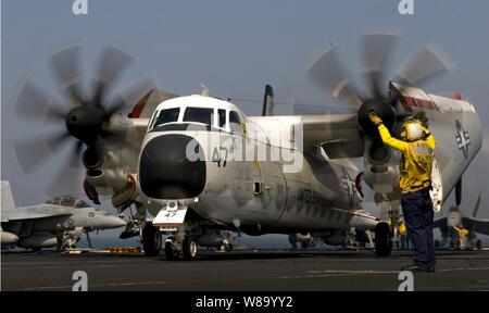 Maître de 2e classe Mario Billote guides un C-2A Greyhound affectés à l'Escadron de soutien logistique de la flotte 40 à bord du porte-avions USS Carl Vinson (CVN 70) en cours dans la mer d'Oman le 3 mars 2011. Le groupe aéronaval du Carl Vinson est déployé des opérations de sécurité maritime et les efforts de coopération en matière de sécurité dans le théâtre dans la 5e Flotte des États-Unis zone de responsabilité. Banque D'Images