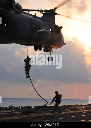 Les Marines américains affectés à la 13e Marine Expeditionary Unit drop d'un hélicoptère CH-46 Sea Knight affectés à l'Escadron 163 Moyen Marin au poste de pilotage du navire d'assaut amphibie USS Boxer (DG 4) tout en menant un exercice de corde dans l'océan Indien le 24 mars 2011. Le boxeur est le fleuron du boxeur groupe amphibie, qui est en cours avec la 13e Marine Expeditionary Unit sur un déploiement de l'ouest de l'océan Pacifique. Banque D'Images