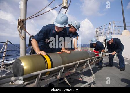 Les marins de la Marine américaine à bord du destroyer lance-missiles USS Chung-Hoon (DDG 93) charger une torpille Mark 46 dans un lanceur pendant qu'ils sont en cours dans l'océan Pacifique le 4 juin 2011. L'Chung-Hoon est sur la création d'un déploiement vers les États-Unis 7e flotte zone de responsabilité. Banque D'Images