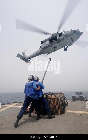 Seaman Matt Binnie (à gauche) et Seaman, Lucio Robles préparer pour attacher un filet d'un MH-60S Sea Hawk au cours d'un ravitaillement vertical à bord du destroyer lance-missiles USS Mitscher (DDG 57) dans le golfe d'Oman le 15 juillet 2011. L'Mitscher est sur le déploiement des opérations de sécurité maritime et les efforts de coopération en matière de sécurité dans le théâtre dans la 5e Flotte des États-Unis zone de responsabilité. Banque D'Images