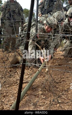 Les soldats de l'armée américaine avec la 38e compagnie du génie, 4e brigade Stryker, 2e Division d'infanterie, placer un explosif de Bangalore pour éliminer un obstacle lors de fil barbelé Sabre Talisman 2011 à la zone d'entraînement de Shoalwater Bay, Queensland, Australie, le 15 juillet 2011. Talisman Saber est une combinaison d'exercice biennal entre les militaires américains et australiens conçus pour améliorer les deux nations. Banque D'Images