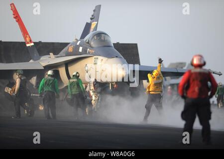 Les marins de la Marine américaine se préparent à lancer un F/A-18C Hornet affectés à 15 e Escadron d'avions à bord du porte-avions USS George H. W. Bush (CVN 77) dans la mer d'Oman le 2 août 2011. Le George H. W. Bush est déployé sur le 5e Flotte des États-Unis zone de responsabilité sur son premier déploiement opérationnel des opérations de sécurité maritime et missions d'appui dans le cadre des opérations Enduring Freedom et New Dawn. Banque D'Images