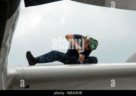 La Marine américaine Maître de 2e classe Ruel Beck s'applique à un produit d'avant-garde d'un panneau d'aile P-3C Orion sur Kadena Air Base à Okinawa, au Japon, le 6 septembre 2011. Beck est un mécanicien structurels de l'Aviation Escadron de patrouille affectée à 40. Banque D'Images