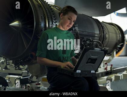 Maître de 3e classe Sarah Stone lit les instructions d'installation d'un extincteur dans un F/A-18E Super Hornet de 14 e Escadron d'avions à bord du porte-avions USS JOHN C. STENNIS (CVN 74) dans la mer d'Oman sur le 6 janvier, 2012. Le John C. Stennis est déployé sur le 5e Flotte des États-Unis zone de responsabilité des opérations de sécurité maritime et missions d'appui dans le cadre de l'opération Enduring Freedom. Banque D'Images