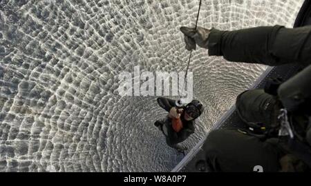 Un marin américain obtient un ascenseur à un MH-60S Sea Hawk à partir d'hélicoptères de l'Escadron de grève 8 membres d'équipage dans la mer d'Oman sur le 17 janvier 2012. Le marin est un technicien des explosifs et munitions. Les membres de l'équipe sont attachés à la John C. Stennis, qui est déployé sur le 5e Flotte des États-Unis zone de responsabilité des opérations de sécurité maritime et missions d'appui dans le cadre de l'opération Enduring Freedom. Banque D'Images