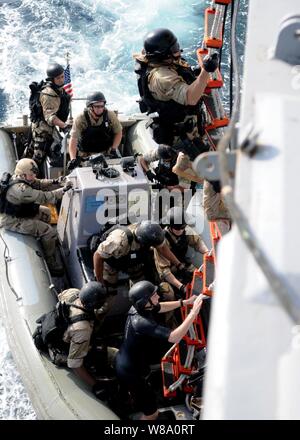 Les marins monter une échelle pendant une visite, un conseil, formation de l'équipe de perquisition et de saisie à bord du destroyer lance-missiles USS Halsey (DDG 97) dans le golfe d'Aden le 25 février 2012. L'Halsey est le navire amiral de la Force opérationnelle combinée 151, une multinationale basée à la mission de l'équipe d'experts travaillant dans des Forces maritimes combinées, de mener des opérations de lutte contre la piraterie dans le sud de la mer Rouge, le golfe d'Aden, bassin somalien, mer d'Oman et l'Océan Indien. Banque D'Images