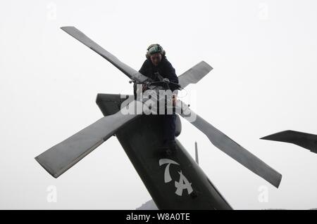 La Marine américaine, le Maître de 3e classe Megan Walters, affecté à l'Escadron d'hélicoptères anti-sous-marin, 51 La Lumière effectue une inspection quotidienne sur un hélicoptère Seahawk SH-60F à bord de la 7ème Flotte américaine USS phare Blue Ridge (LCC 19) à Busan, Corée du Sud, le 26 février, 2012. Banque D'Images