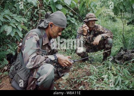 Royal Thai Air Force Sgt. Sutthiphan Jankeeree (à gauche) et le sergent-chef de l'US Air Force. Joe Sitterly (droite) communiquer sur un PRC-90 Radio HF dans le cadre de formation en recherche et sauvetage à Khao Na Ting, Thaïlande, le 13 mai 1996, au cours de l'exercice Gold Cobra Ф96. Gold Cobra Ф96 est la dernière d'une série d'exercices militaires des États-Unis/Thaï conçu pour assurer la paix et à renforcer la capacité de l'Armée royale thaïlandaise à défendre en Thaïlande. Environ 9 000 aux États-Unis et 10 000 membres du personnel thaïlandais participent à l'exercice. Jankeeree est attaché à la coordination des opérations de sauvetage, de Bangk Banque D'Images