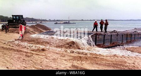 À partir de la U.S. Navy Seabees 1er Bataillon de construction de l'amphibie a frappé la marque le 23 février 1997, après des jours de mauvais temps retardé l'insertion d'une jetée flottante portable à plage d'eau douce, Rockhampton, Australie. Les Seabees participent à l'exercice Tandem Thrust Ф97, un exercice d'entraînement militaire combiné impliquant 28 000 personnes, 252 avions et 43 navires, et il est conçu pour former des équipes américaines et australiennes dans la planification d'action de crise et d'urgence des opérations d'intervention. Banque D'Images