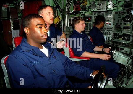 Timonier de quart apprenti pompier Darrell Rogers (à gauche), sous-officier de quart Premier maître de Scott Fletcher (centre), et de l'Planesman regarder le Maître de 3e classe Rocky Bolin (centre droit), de manœuvrer le sous-marin d'attaque rapide USS Annapolis (SSN 760) dans les eaux du golfe Persique le 29 novembre, 1997. Le sous-marin nucléaire fonctionne dans le golfe Persique dans le cadre de l'USS George Washington (CVN 73) à l'appui de l'opération Southern Watch qui est aux États-Unis et de la coalition de l'application de la zone d'exclusion aérienne au-dessus du sud de l'Iraq. Rogers est de Birmingham, Banque D'Images