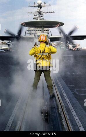 Maître de 3e classe Kevin P. Spurrell dirige un E-2C Hawkeye sur l'une des catapultes bow pendant les préparatifs de lancement sur le pont du porte-avions USS Nimitz (CVN 68) le 24 décembre, 1997. Le Nimitz et entrepris Carrier Air Wing 9 fonctionnent dans le golfe Persique dans le cadre de l'opération Southern Watch qui est aux États-Unis et de la coalition de l'application de la zone d'exclusion aérienne au-dessus du sud de l'Iraq. Spurrell est un boatswainХs aviation Marine mate de Duncanville, Texas. Banque D'Images