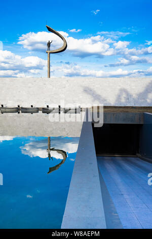 Photo du JK Memorial, à Brasilia, vu de l'arrière, avec un reflet de la statue dans l'étang et bleu ciel derrière Banque D'Images