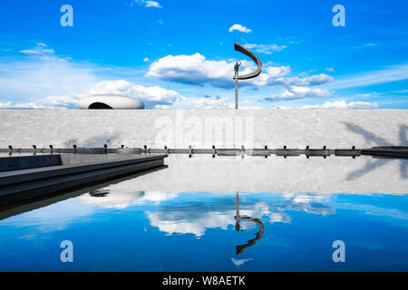 Photo du JK Memorial, à Brasilia, vu de l'arrière, avec un reflet de la statue dans l'étang et bleu ciel derrière Banque D'Images