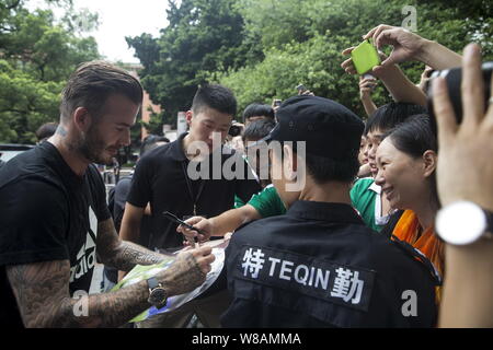 La star du football anglais David Beckham signe des autographes pour les fans lors d'une campagne de football par Adidas à Zhixin High School dans la ville de Guangzhou, en Chin Banque D'Images