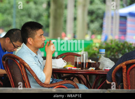 --FILE--un Chinois fume une cigarette à un thé dans la ville de Hangzhou, Zhejiang Province de Chine orientale, le 31 mai 2016. La quantité de tabac vendus dans Banque D'Images