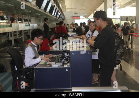 L'acteur de Hong Kong Lau Hawick, avant droit, accompagne son épouse, l'actrice chinoise Yang Mi, invisibles, pour obtenir sa carte d'embarquement avant le départ de la Hong K Banque D'Images