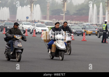 --FILE--cyclistes chinois ride vélos électrique à travers la place Tiananmen à Beijing, Chine, 6 avril 2016. Le nombre croissant de conducteurs de voiture privée Banque D'Images