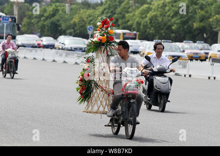 --FILE--cyclistes chinois ride vélos électrique à travers la place Tiananmen à Beijing, Chine, 3 juillet 2013. Le nombre croissant d'automobilistes je Banque D'Images