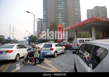 --FILE--voitures font la queue jusqu'à faire le plein à une station-service de PetroChina, filiale de la CNPC (China National Petroleum Corporation), à Hangzhou, à l'est Ch Banque D'Images