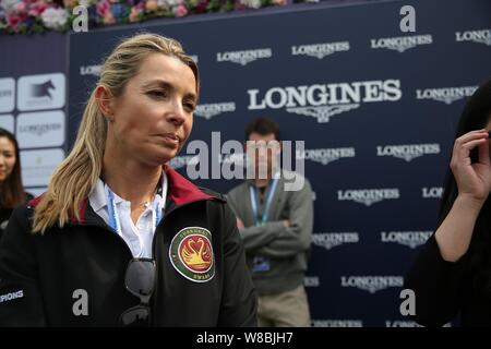 Edwina Alexander de l'Australie, avant, assiste à un geste pour l'épreuve de relais 2016 Global Champions Tour Longines Shanghai à Shanghai, Chine, le 28 avril Banque D'Images