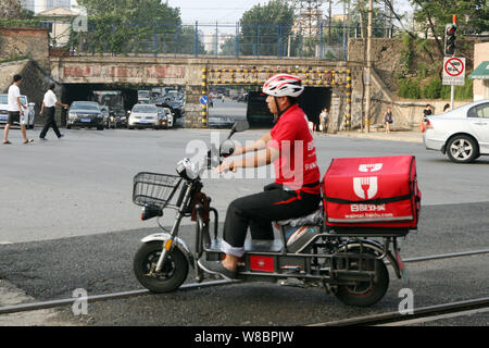 --FILE--un livreur chinois Baidu est en ligne de service de livraison de nourriture en waimai.baidu.com un vélo électrique pour fournir de la nourriture sur une route dans la ville de Dalian Banque D'Images