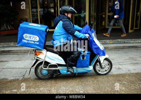 --FILE--un livreur de l'entreprise de livraison de repas chinois Ele.me chevauche son vélo électrique à livrer des repas sur une rue de ville de Hangzhou, Chine, Moyen-Orient Zhej Banque D'Images