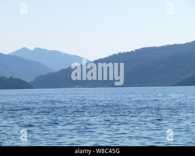 Vue de la mer à la îles montagneuses de la côte, dans la matinée. Seascape pittoresque littoral, avec les montagnes et les collines couvertes par la forêt dans la brume Banque D'Images