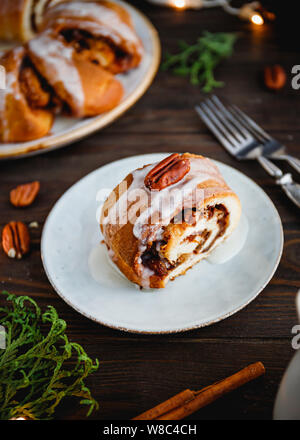 Morceau de gâteau de Noël suédois anneau thé à la cannelle, les pacanes et les raisins secs sur une chaude chandail tricoté. Le concept de vacances d'hiver douillet et des Banque D'Images