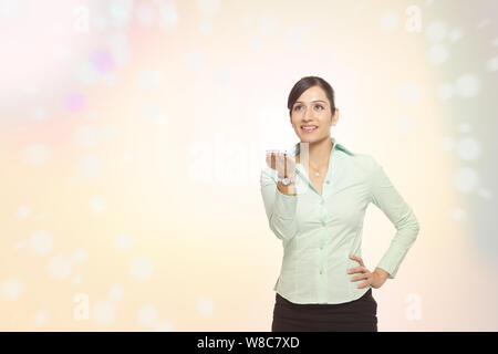 Femme d'affaires utilisant un smartphone et des lumières en streaming à partir de lui Banque D'Images