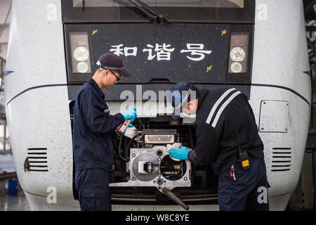 Techniciens chinois examiner un CRH (China railway High-speed), le train pour le prochain Nouvel An chinois ou la fête du printemps à la maintena Banque D'Images