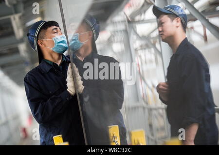 Techniciens chinois examiner un CRH (China railway High-speed), le train pour le prochain Nouvel An chinois ou la fête du printemps à la maintena Banque D'Images