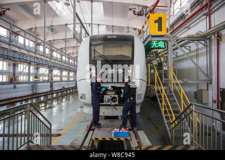 Techniciens chinois examiner un CRH (China railway High-speed), le train pour le prochain Nouvel An chinois ou la fête du printemps à la maintena Banque D'Images