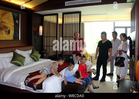 Les parents chinois et leurs enfants visiter une chambre d'une villa de luxe au cours d'une visite à stimuler le désir d'enfants devenus riches et réussi à Banque D'Images