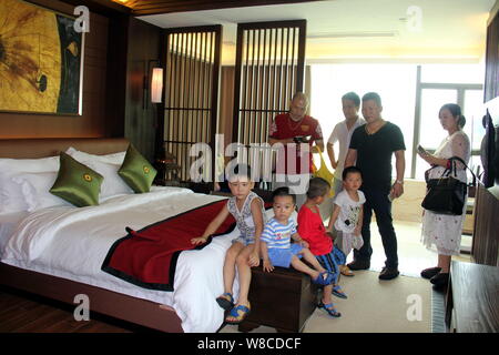 Les parents chinois et leurs enfants visiter une chambre d'une villa de luxe au cours d'une visite à stimuler le désir d'enfants devenus riches et réussi à Banque D'Images