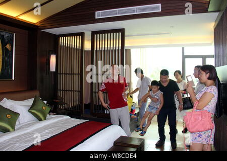 Les parents chinois et leurs enfants visiter une chambre d'une villa de luxe au cours d'une visite à stimuler le désir d'enfants devenus riches et réussi à Banque D'Images