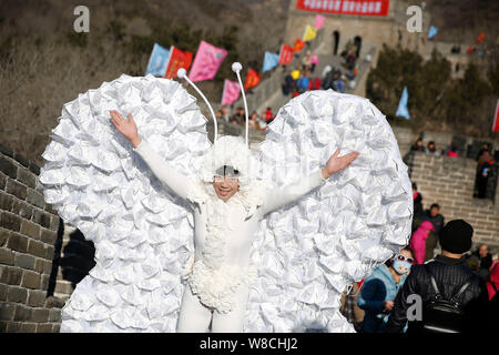 L'artiste chinois Kong Ning, droit, vêtu d'un costume de papillon fait avec 365 masque de visage pose à la Grande Muraille de Badaling, à la périphérie de Beijing, Banque D'Images