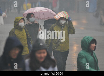 La plupart des piétons, qui portent des masques, marcher dans une rue de smog lourds à Shenyang city, Liaoning Province du nord-est de la Chine, le 8 novembre 2015. Il Banque D'Images