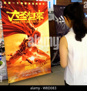 --FILE--une filmgoer chinois ressemble à une affiche pour le film 'Monkey King : Hero est de retour" dans un cinéma à Yichang city, province du Hubei en Chine centrale, 19 Banque D'Images