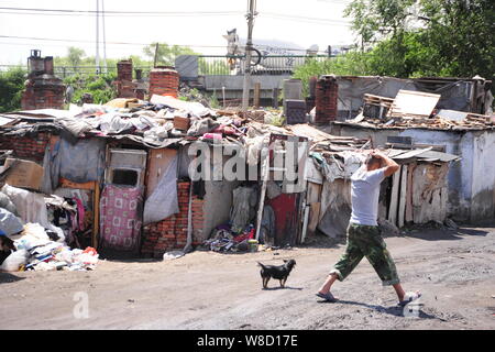 --FILE--un résident chinois locaux miteux marche dernières maisons dans la ville de Harbin, province de Heilongjiang, Chine du nord-est, le 20 juillet 2014. Les statistiques officielles Banque D'Images