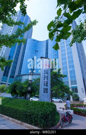 --FILE--un piéton passe devant une pancarte de Dongxing Securities à Pékin, Chine, le 5 juillet 2015. Le conseil d'Dongxing Securities a réduit le Banque D'Images