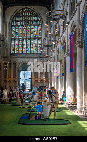 Enfants jouant au minigolf dans la nef de la cathédrale de Rochester Kent UK Banque D'Images