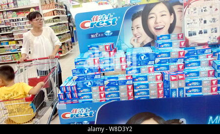 --FILE--un client chinois pousse un panier de boîtes passé du P&G dentifrice Crest approuvé par Taiwanese TV 24,99 Dee Hsu dans un supermarché dans la région de Na Banque D'Images