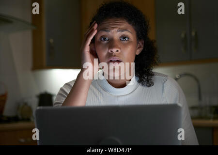 Portrait de femme malheureuse à la maison avec l'ordinateur victime en ligne Banque D'Images