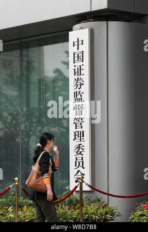 --FILE--un piéton parle sur son téléphone portable alors qu'elle entre dans le siège de la China Securities Regulatory Commission (CSRC), à Beijing, Chine, Banque D'Images